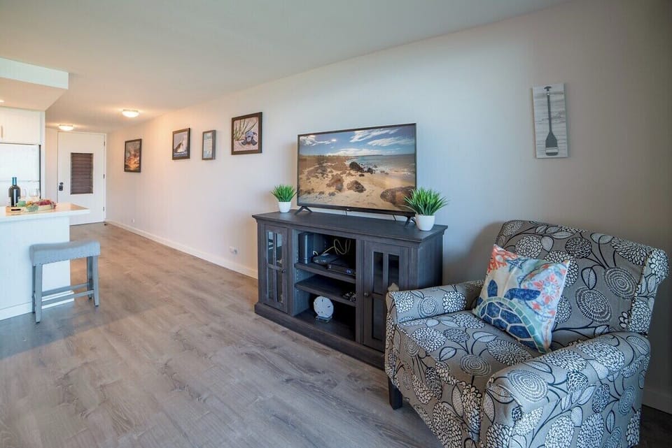 Stylish lounge with armchair, TV, and framed art—perfect for winding down