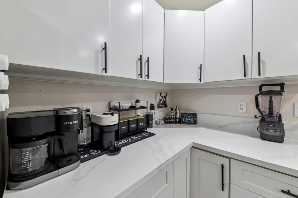 Your private kitchen corner features premium coffee station, high-end blender, and sleek white cabinetry for all your culinary adventures.