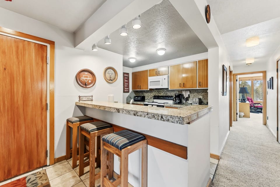 Your open kitchen features granite counters, modern appliances, and a breakfast bar perfect for morning coffee or casual dining.