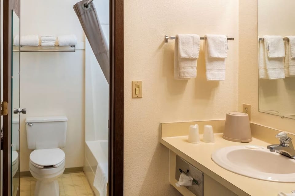 Refresh in a spotless bath with plush towels, bright vanity.