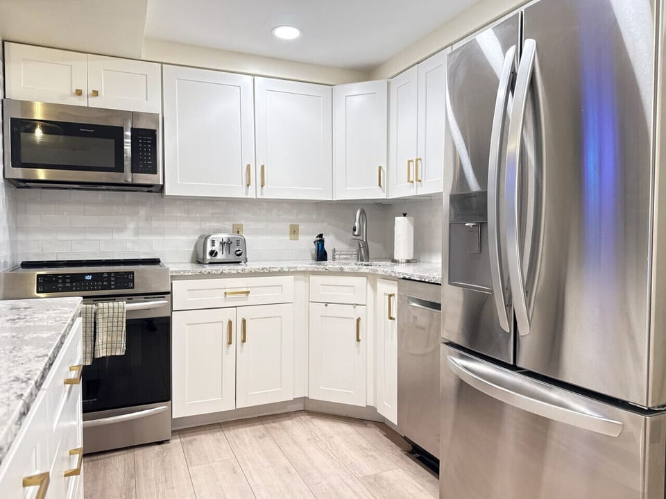 Bright, high-end kitchen with stainless appliances.