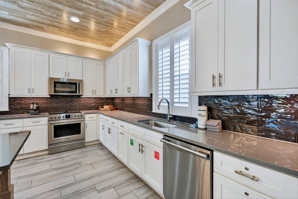 1st Floor Kitchen & Dining — Open-concept chef’s kitchen with modern appliances and generous counter space, paired with a spacious dining area offering seating for 12 guests, ideal for family meals, celebrations, and effortless group entertaining.