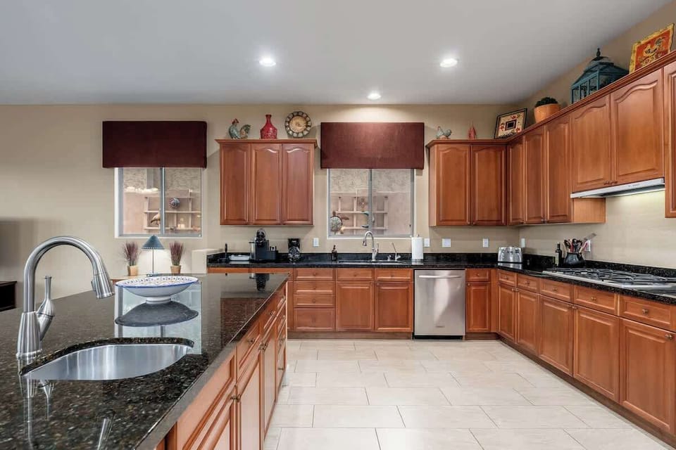 Your gourmet kitchen awaits with gleaming granite countertops, warm wood cabinetry, and stainless appliances—plenty of space to prep memorable meals and gather around.
