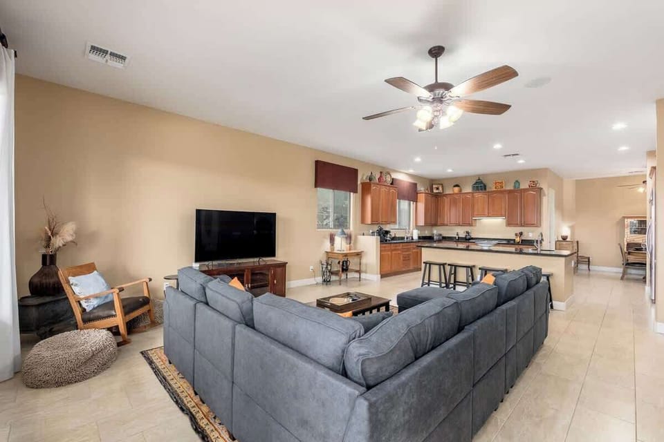 Settle into the spacious open-plan living area where plush seating, a fully equipped kitchen, and warm lighting create your perfect home base for unforgettable desert escapes.
