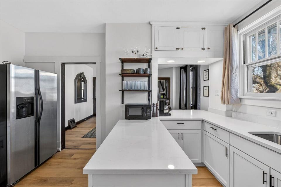 The kitchen also features a large fridge and large windows.