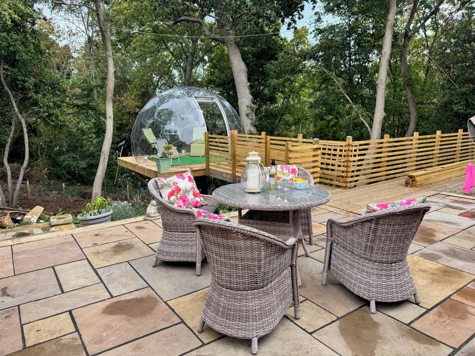 Sea Breeze - large terrace with dining table overlooking the wooded garden area