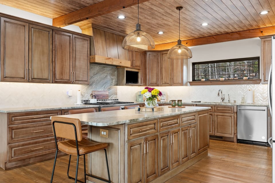 This inviting kitchen brings everyone together. Warm wood cabinetry, a spacious island, and soft pendant lighting make it easy to cook, chat, and linger—whether it’s coffee in the morning or a relaxed dinner after a day on the lake.