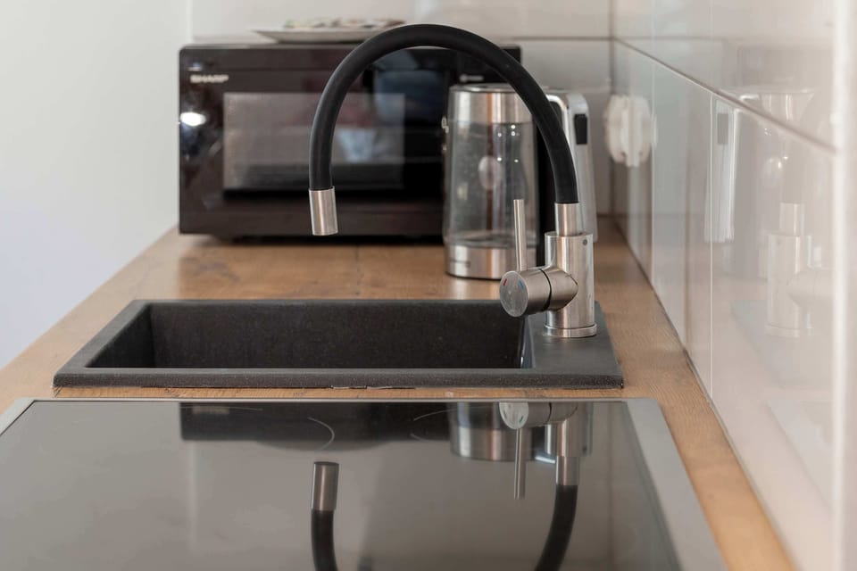 Functional kitchenette detail featuring a sink and microwave.