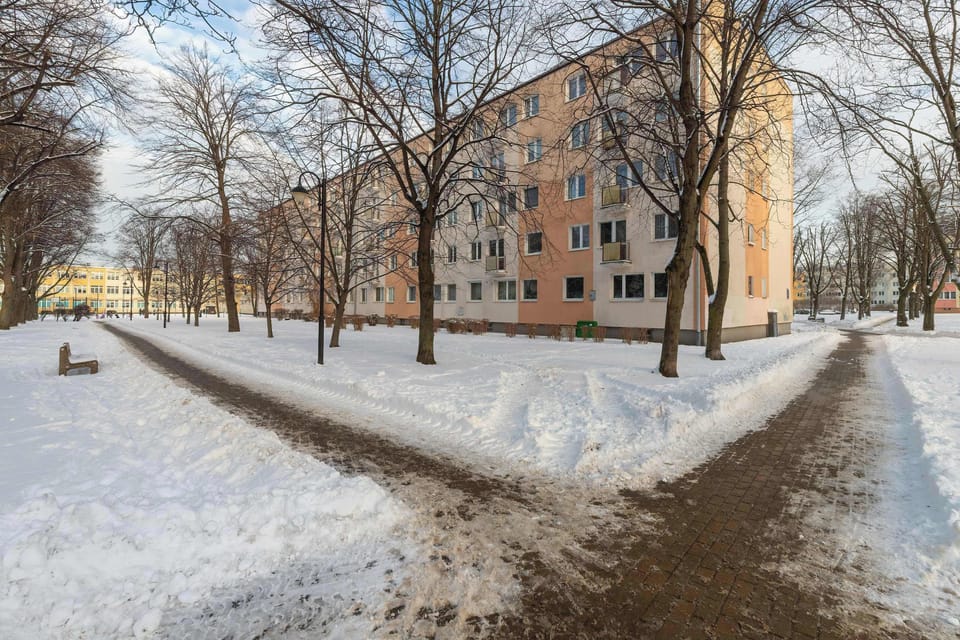 Residential building exterior surrounded by trees and a quiet neighborhood setting.