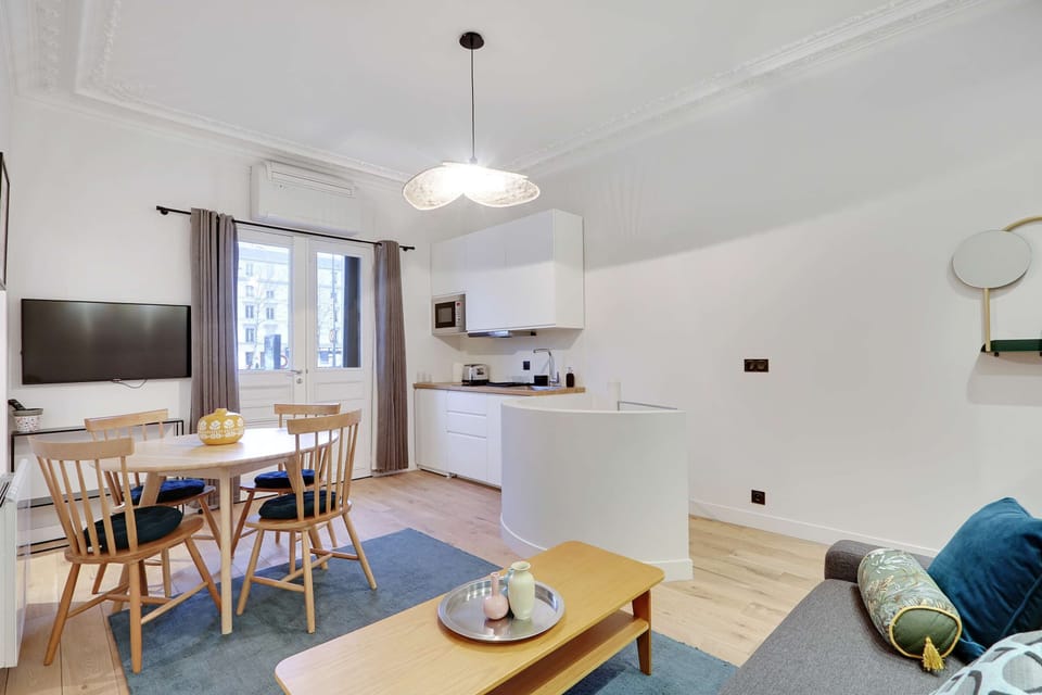 Salon confortable avec un canapé, TV et table à manger