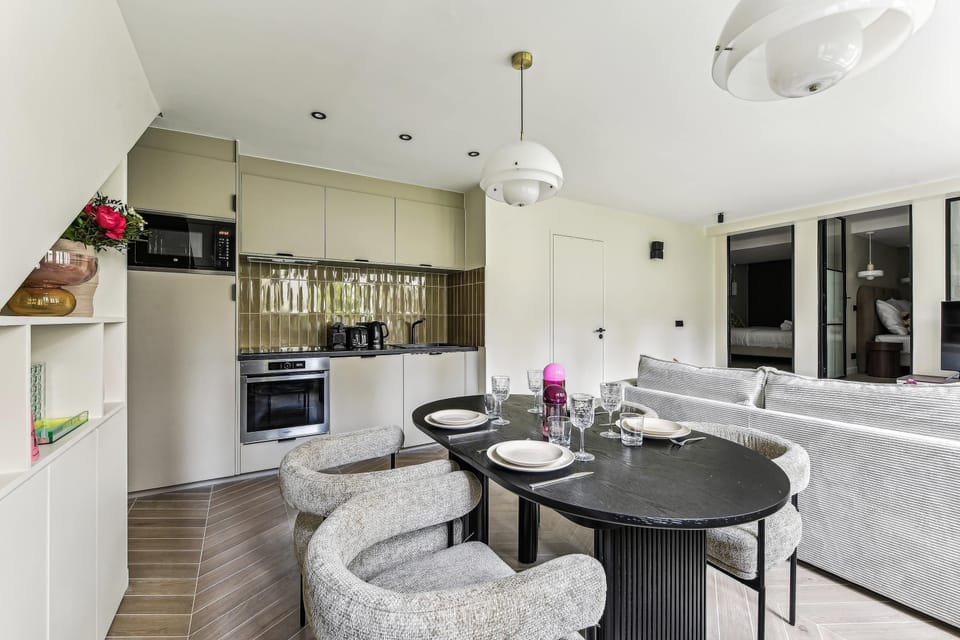 Salon confortable avec canapé convertible, TV et table à manger 