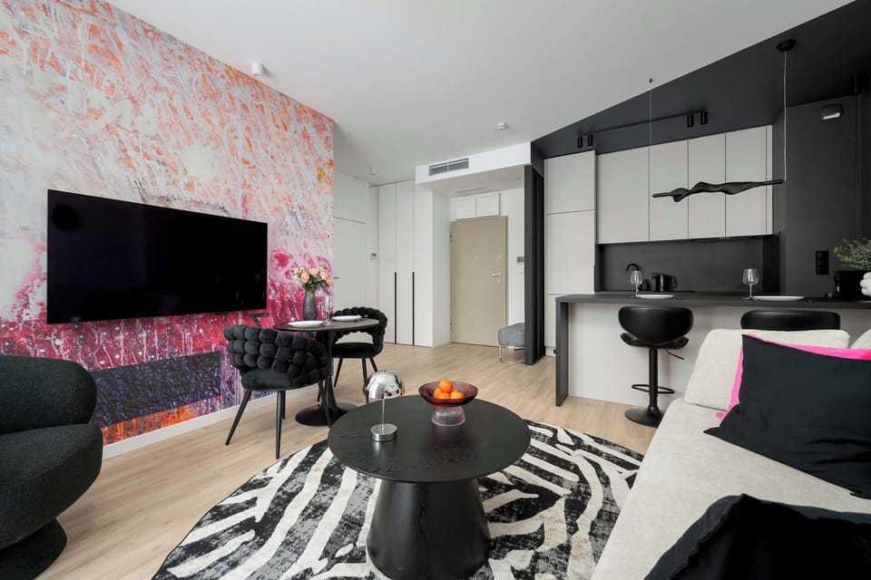 The living area features a sleek coffee table and a flat-screen television.