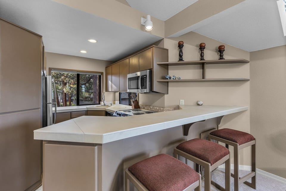 Your fully equipped kitchen features modern appliances and a breakfast bar where you can enjoy morning coffee.