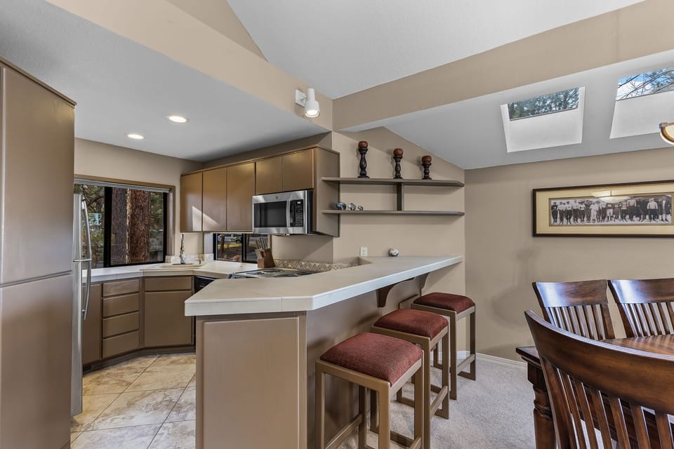 Your spacious kitchen welcomes you with sleek countertops, modern appliances, and a breakfast bar perfect for morning coffee under natural skylights.