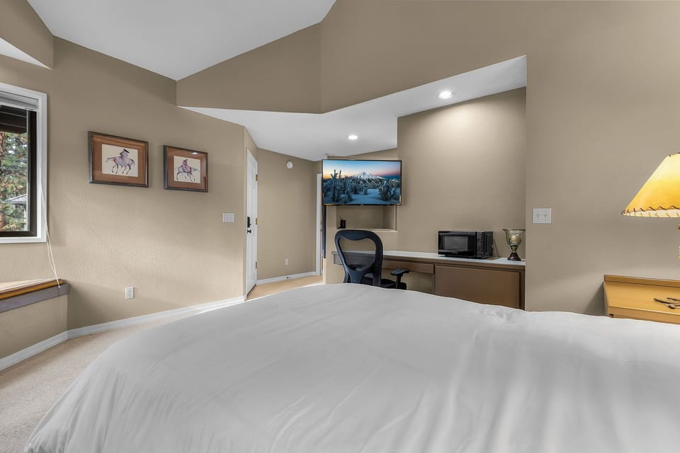 Rest easy on your plush bed while enjoying modern comforts like the wall-mounted TV and dedicated workspace with ergonomic chair.