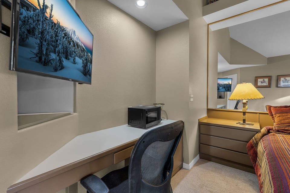 Your dedicated workspace features a sleek desk, ergonomic chair, and microwave for convenient snacks during productive sessions.