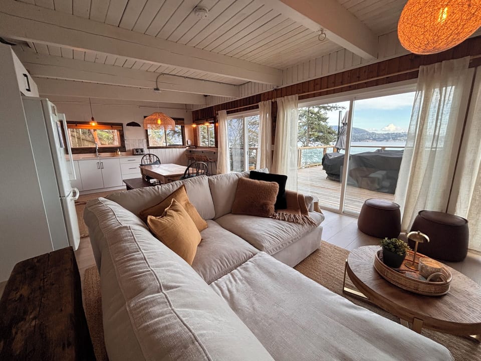 Refreshed living room to kitchen view in the Salt Cabin. Turn towards the windows and all you see is deck and ocean! 