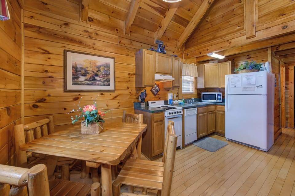 Your rustic cabin kitchen invites cozy meals with warm wood beams overhead and everything needed for home cooking adventures.