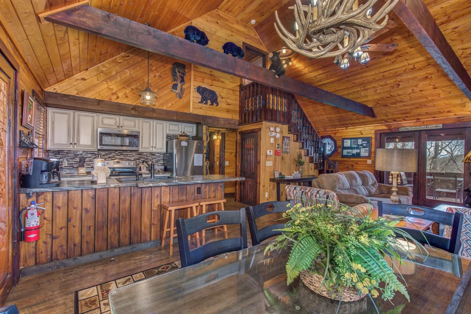 Step into your rustic retreat with soaring wood ceilings, antler chandelier, and open kitchen perfect for gathering around the dining table.