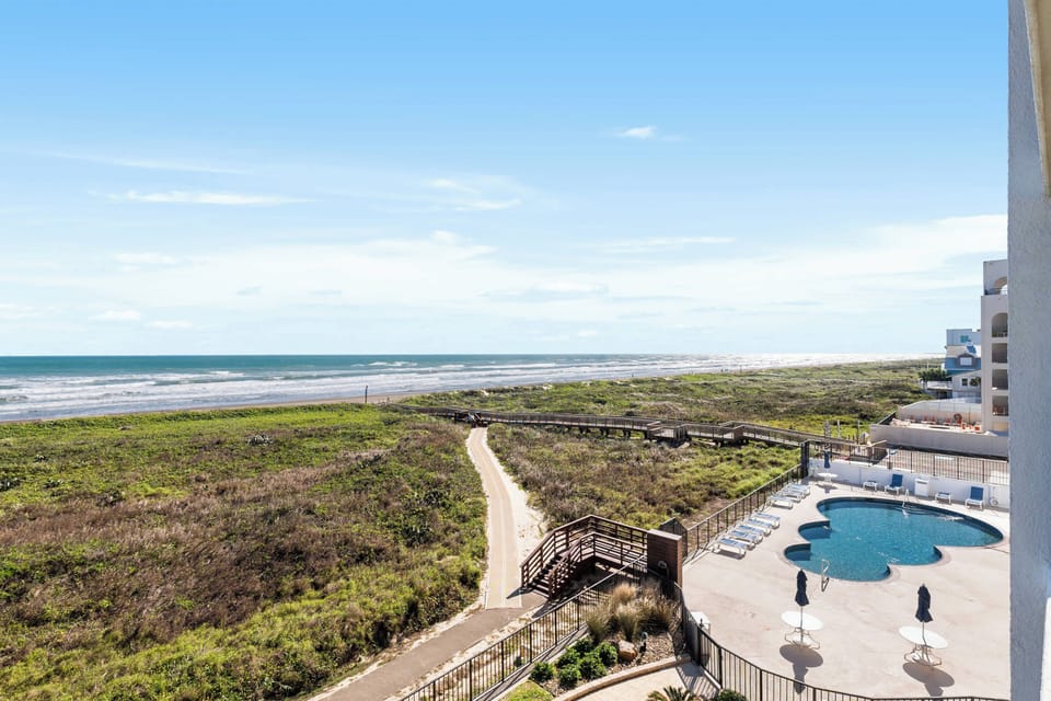 Resort pool views + beachside scenery below
