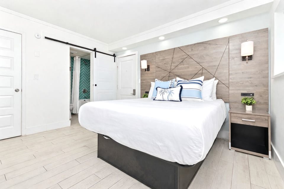 Comfortable queen bed with crisp linens, air conditioning, heating, TV, clothing storage, and room-darkening shades. Extra pillows and blankets provided for a restful stay.