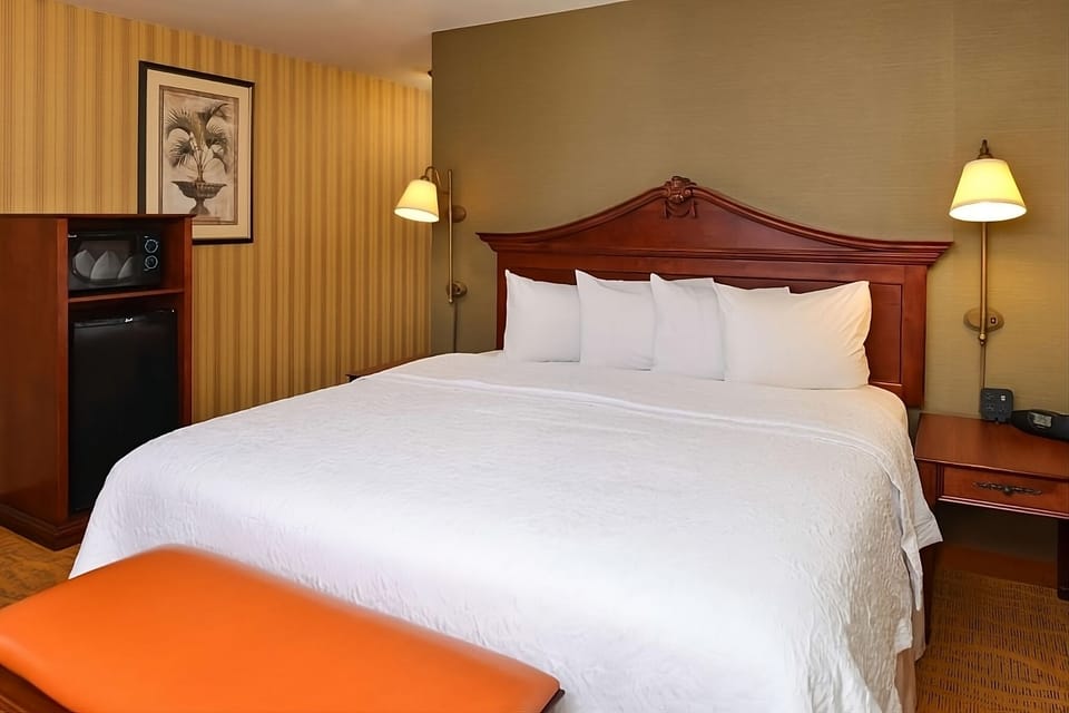 Sink into crisp white linens beneath warm bedside lighting.