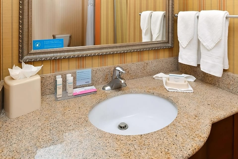 Refresh at the granite vanity with plush towels waiting.