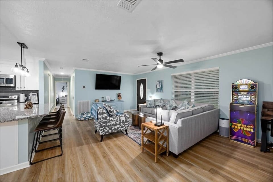 Open-concept living area with bar seating, comfortable couches, a 65" TV, and entertainment features—ideal for relaxed nights in or gathering together.