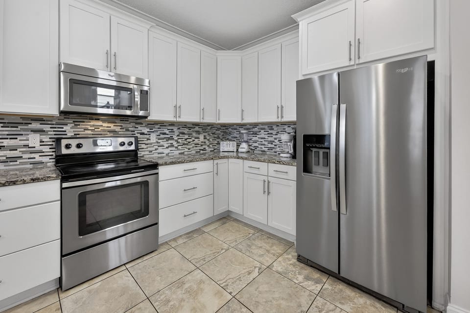 Large open kitchen with stainless steel appliances. 