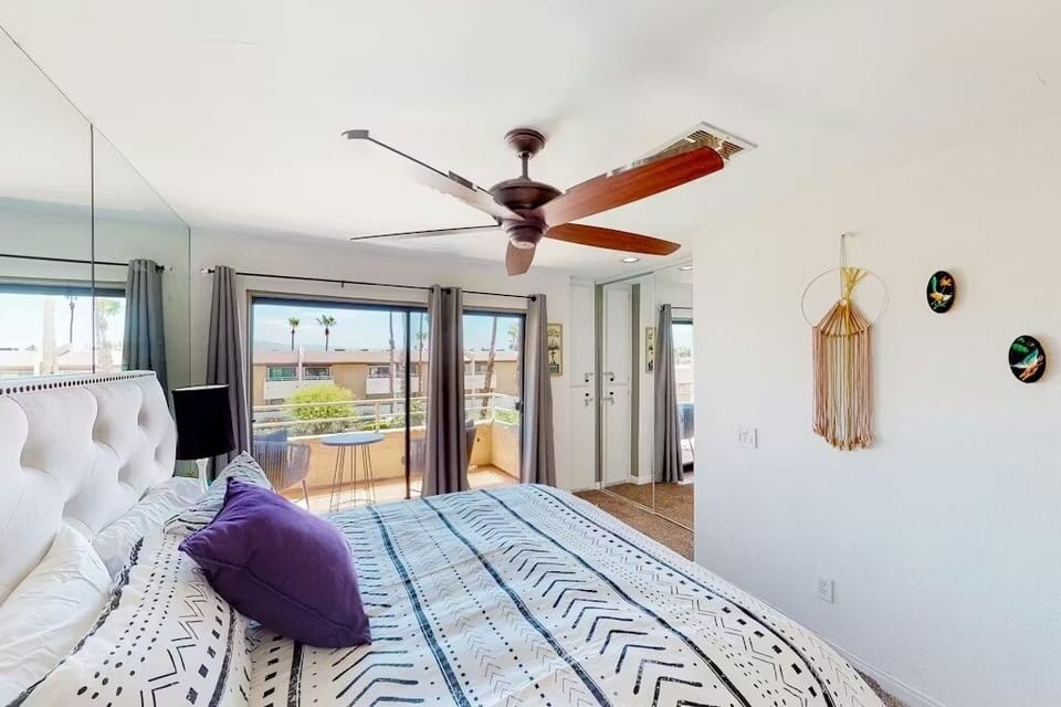 Primary bedroom with balcony access, natural light, and resort views