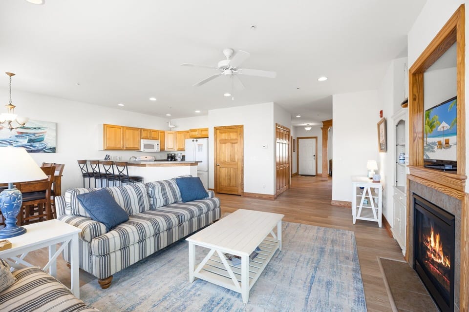 The main living area features a gas fireplace, flat-screen TV, and comfortable seating, creating a welcoming space for family or friends to gather.