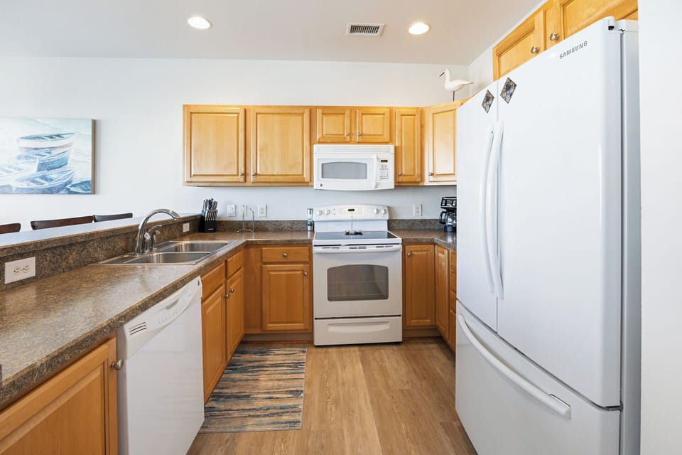 The fully equipped kitchen includes modern appliances and a breakfast bar, making meal prep easy and enjoyable during your stay.