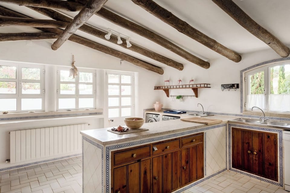 With wooden beams and tiled countertops, this fully equipped kitchen blends rustic charm with practicality.