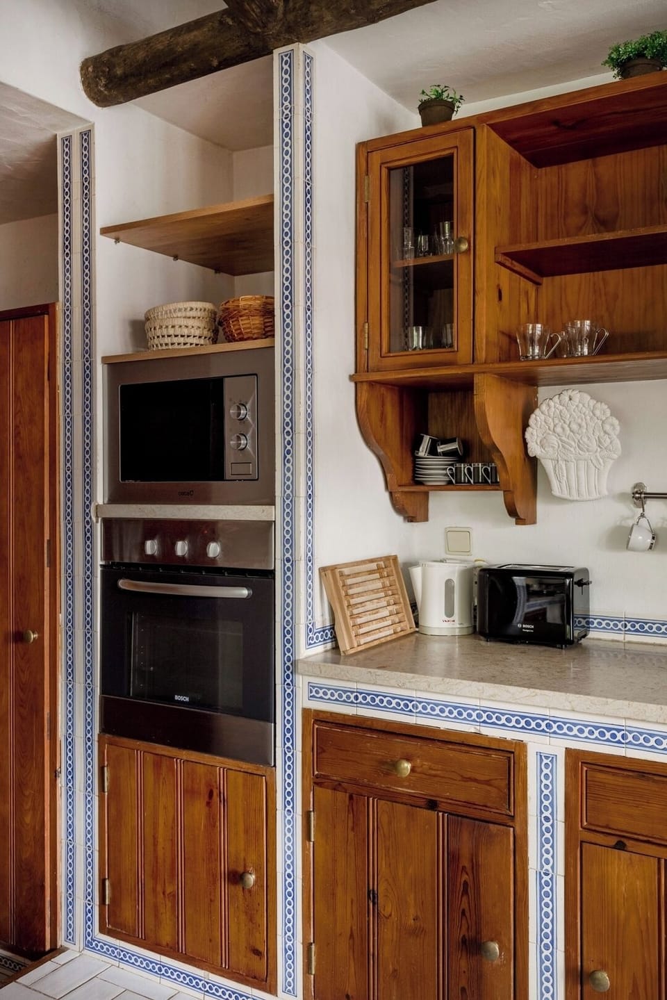 With wooden beams and tiled countertops, this fully equipped kitchen blends rustic charm with practicality.