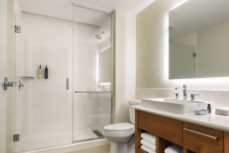 Refresh under a sleek glass shower in a spotless bath.