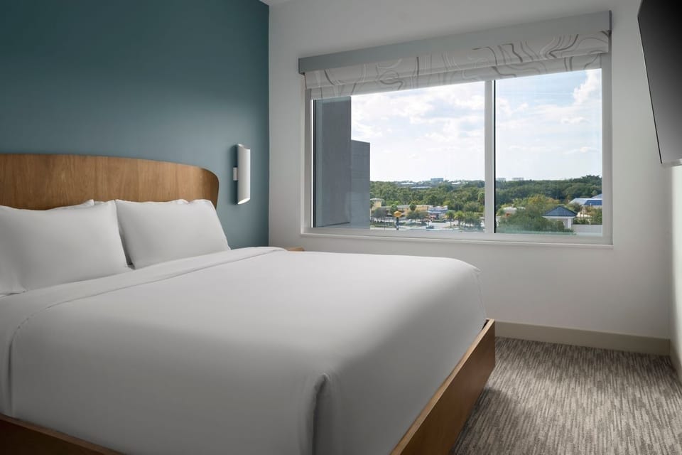 Stretch out on a serene king bed beside sunny windows.