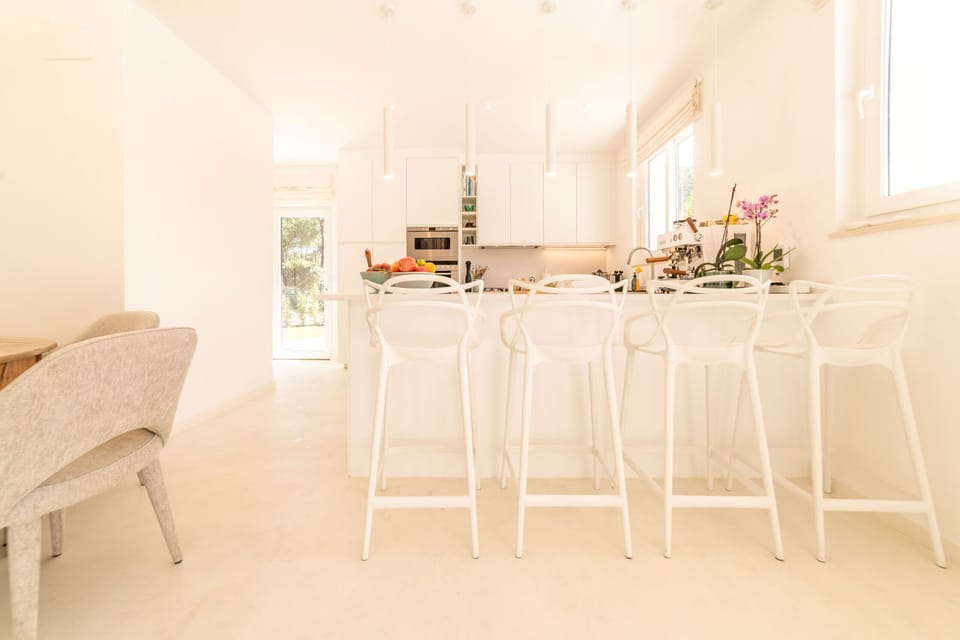 Bright open-plan kitchen and dining area with white bar stools — Villa Aroeira I, holiday villa in Herdade de Aroeira