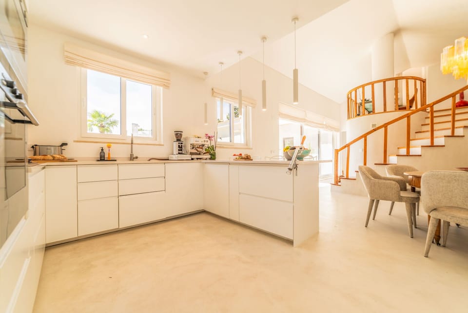 Bright open-plan kitchen with wooden staircase — Villa Aroeira I, holiday villa in Herdade de Aroeira
