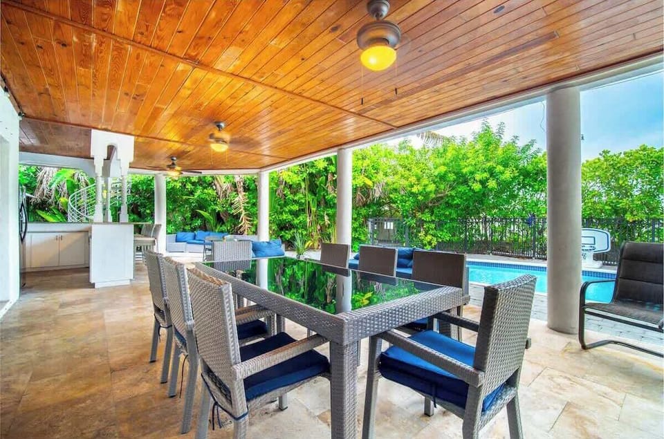Enjoy the ultimate backyard getaway with a private pool, comfy lounge area, spacious outdoor dining, and a built-in grill, perfect for sunny brunches, evening dinners, and fun poolside gatherings in a relaxing tropical setting.