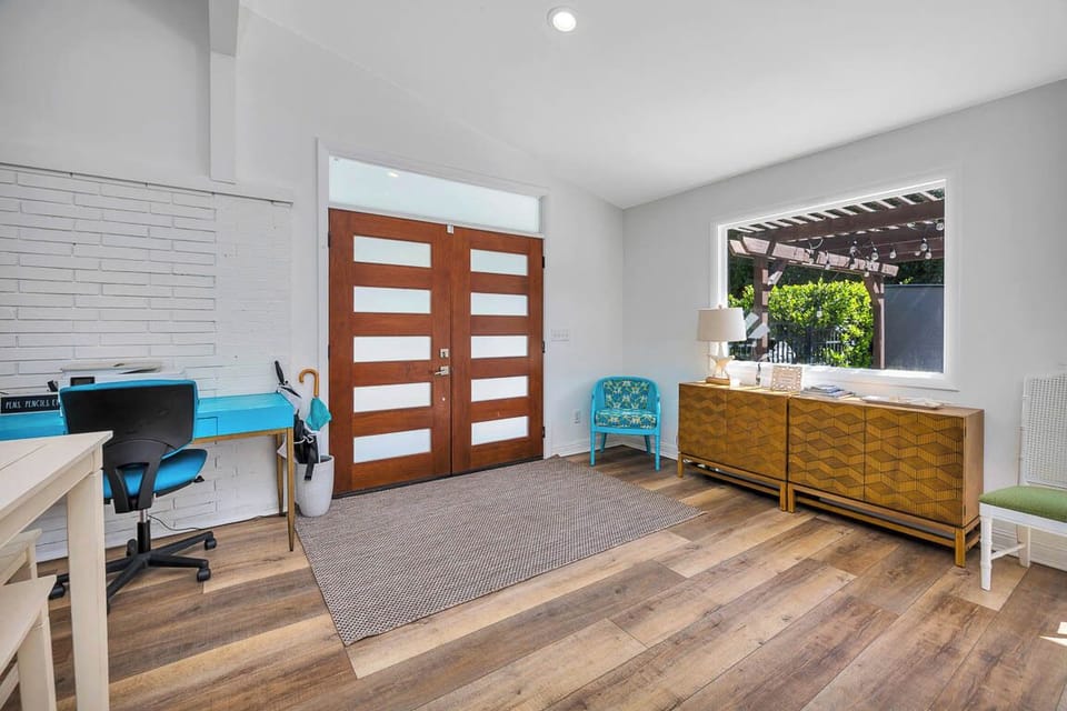Main House Entry into Living Room – 530 Delegal - Entryway into the main house at 530 Delegal opening directly into the living room, with wood floors, modern front door, and courtyard-facing window.