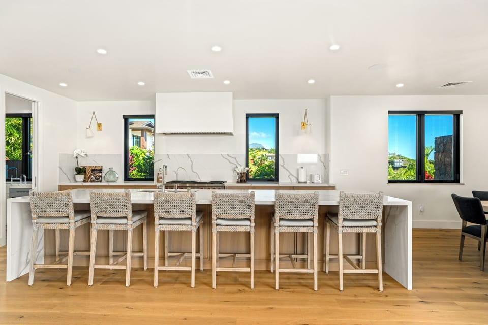Gather around this stunning kitchen island where quartz countertops and woven bar stools create the perfect spot for morning coffee or evening conversations.