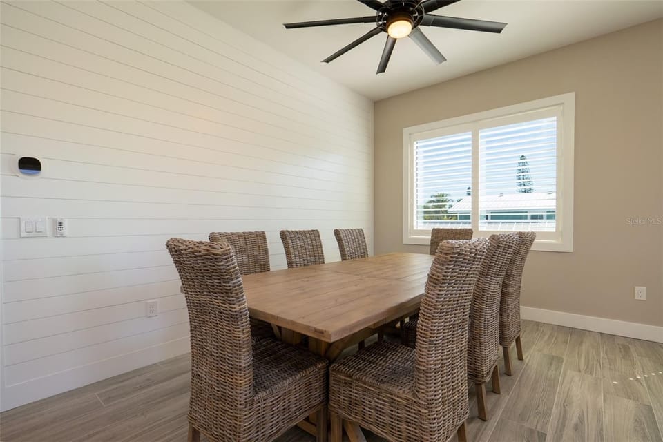 Gather around your spacious dining table where coastal-inspired wicker chairs and warm wood create the perfect setting for memorable meals together.