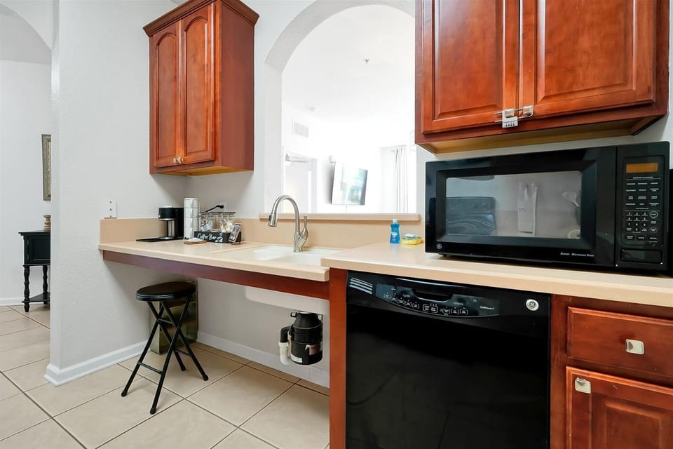Your fully equipped kitchen features warm cherry cabinets, modern appliances, and a convenient breakfast bar for quick meals.