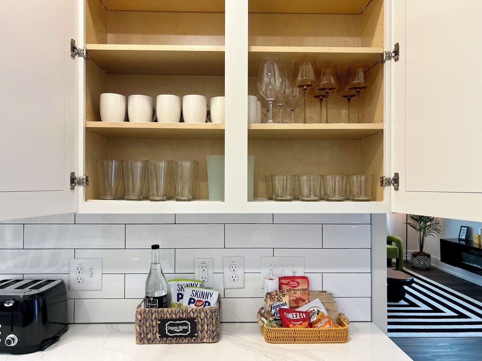 Stocked kitchen with mugs, glassware, snacks, toaster & coffee bar