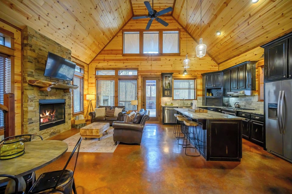 Bright open living area with fireplace and modern kitchen design.