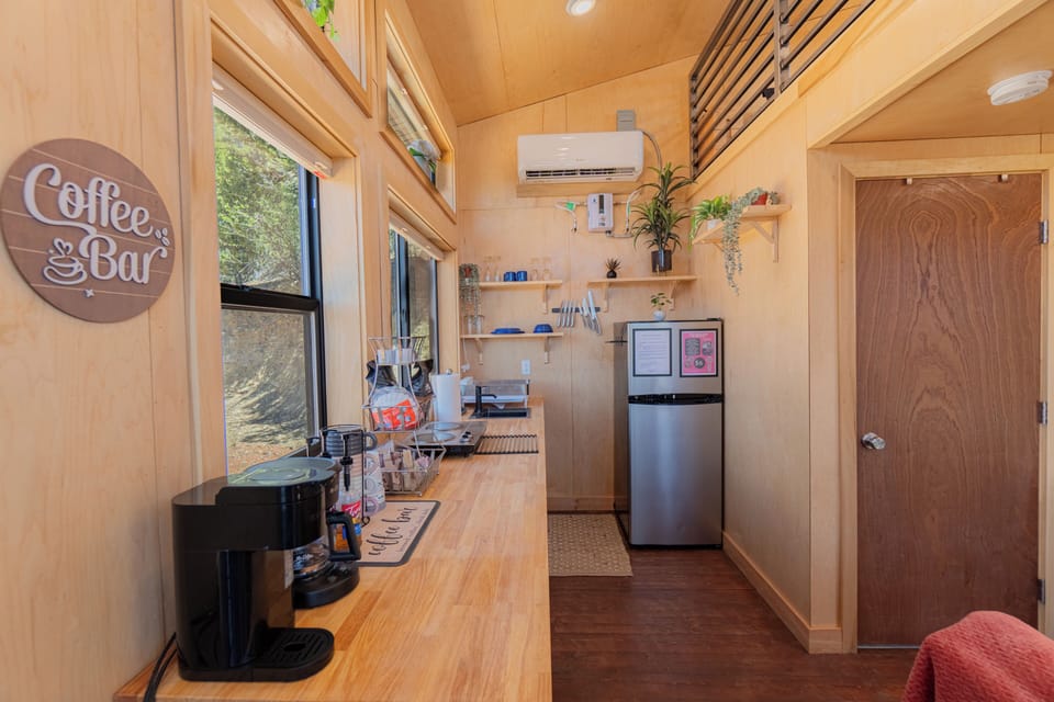 Bright kitchenette with coffee bar, mini fridge, freezer and cozy cabin charm