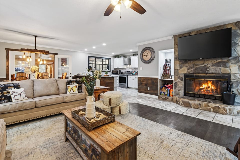 Warm up indoors in this inviting living room, where a stone fireplace, plush seating, and rustic details set the tone for cozy mountain nights.