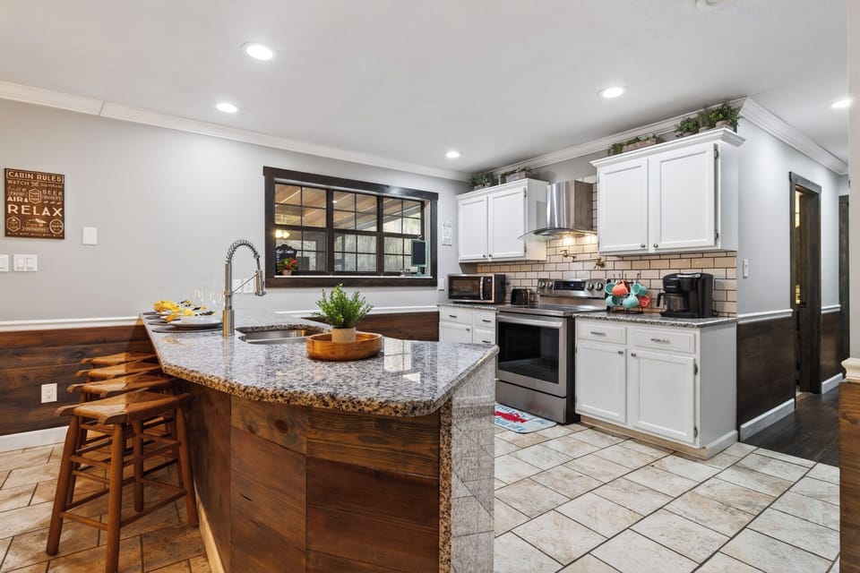 Gather around the spacious kitchen island, featuring granite counters, bar seating, and a fully equipped kitchen made for easy entertaining.