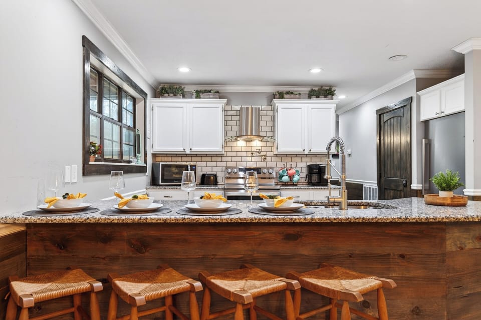Gather around the spacious kitchen island, featuring granite counters, bar seating, and a fully equipped kitchen made for easy entertaining.