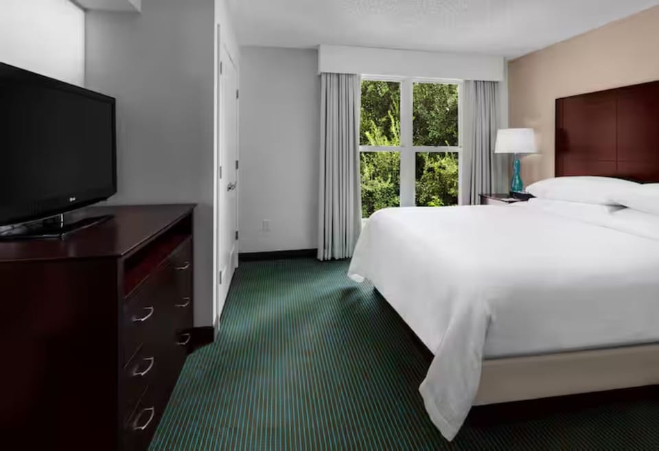 Unwind in crisp linens with calming treetop views outside.